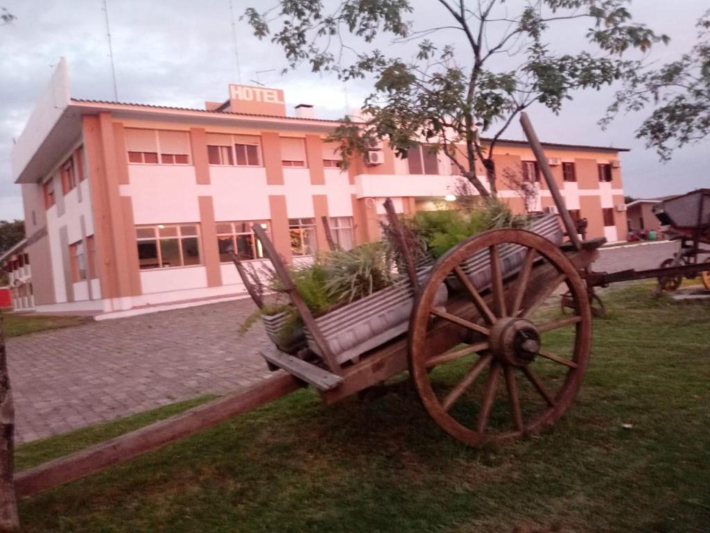 a wooden cart with plants on it in front of a building at Cyro Palace Hotel Ltda in Caçapava do Sul