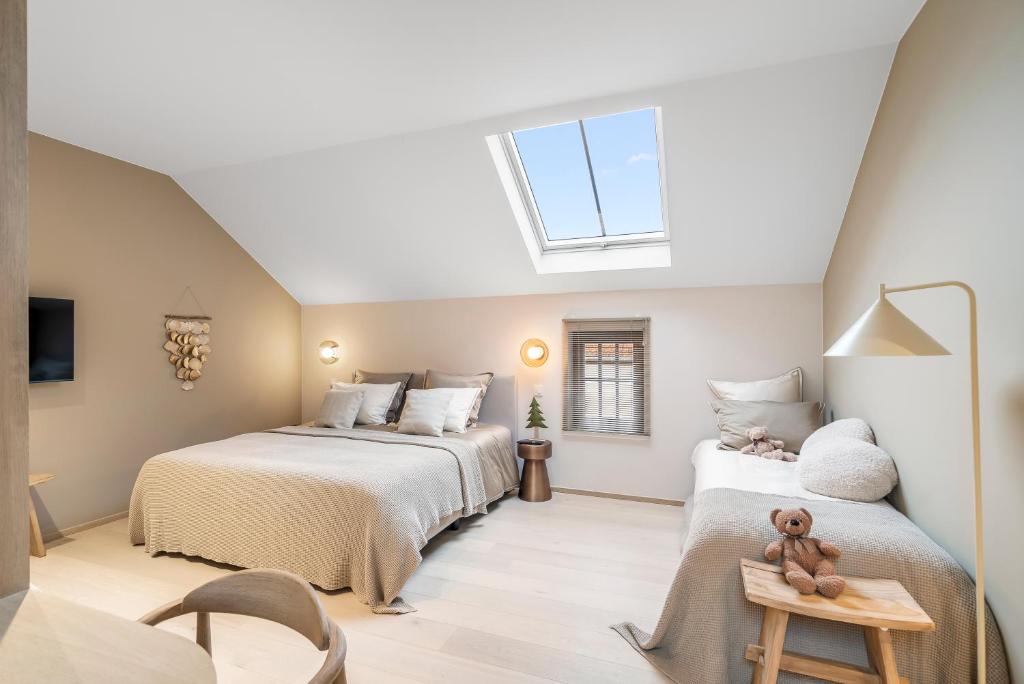 a attic bedroom with two beds and a skylight at De Kompanie in Alken