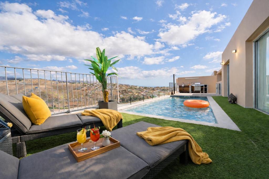 a living room with a couch and a swimming pool at Villa Trilux, Infinity Pool, Jacuzzi, BBQ in Salobre