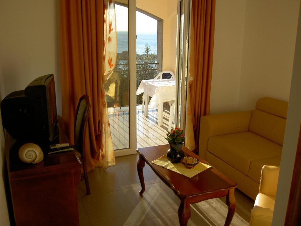 a living room with a couch and a table and a balcony at Apartmani More in Sveti Stefan