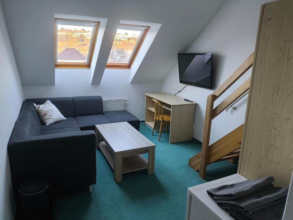 a small living room with a couch and a tv at Penzion-BelBar Zlín in Zlín