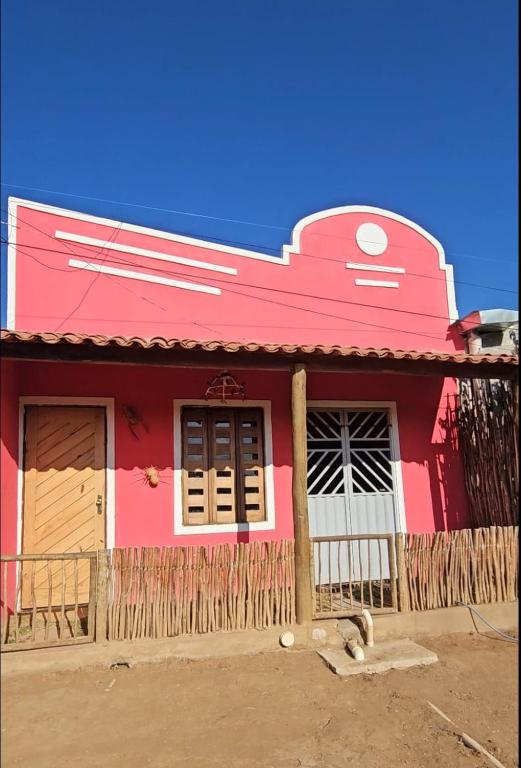 a pink house with a fence in front of it at Casa Corrupião - Ilha do Ferro - Alagoas in Pão de Açúcar