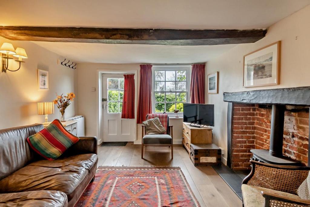 a living room with a couch and a fireplace at 2 Bed in Walberswick oc-h29096 in Walberswick