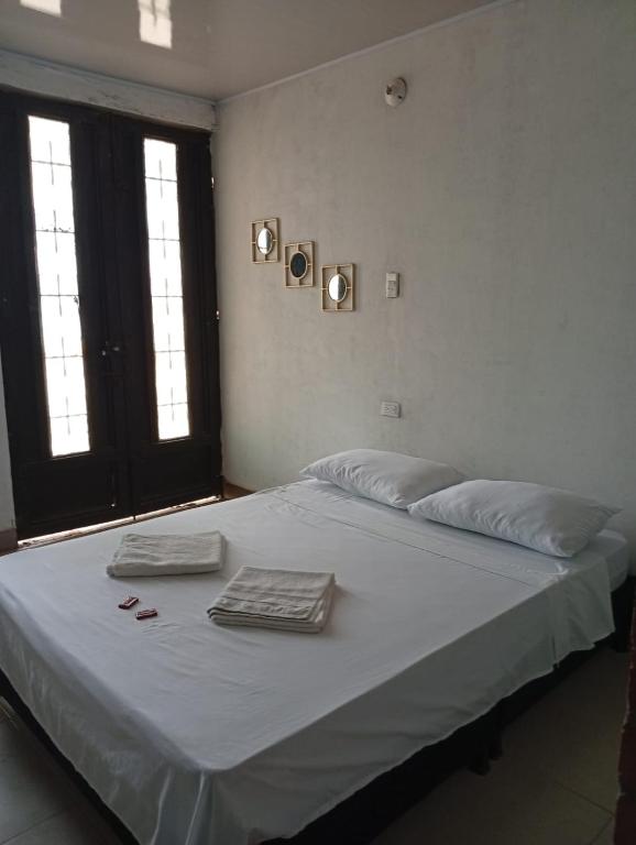 a bed in a bedroom with two towels on it at CASA HOTEL EL PRADo in Mesetas
