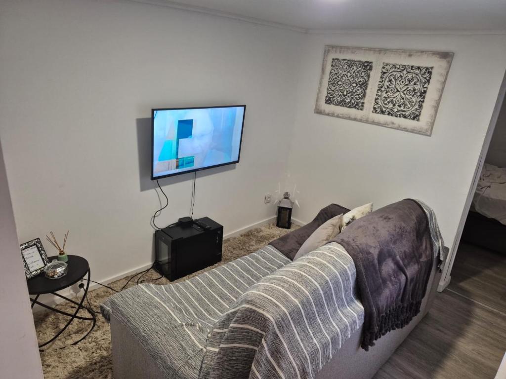 a living room with a couch and a flat screen tv at T1 Amadora in Amadora