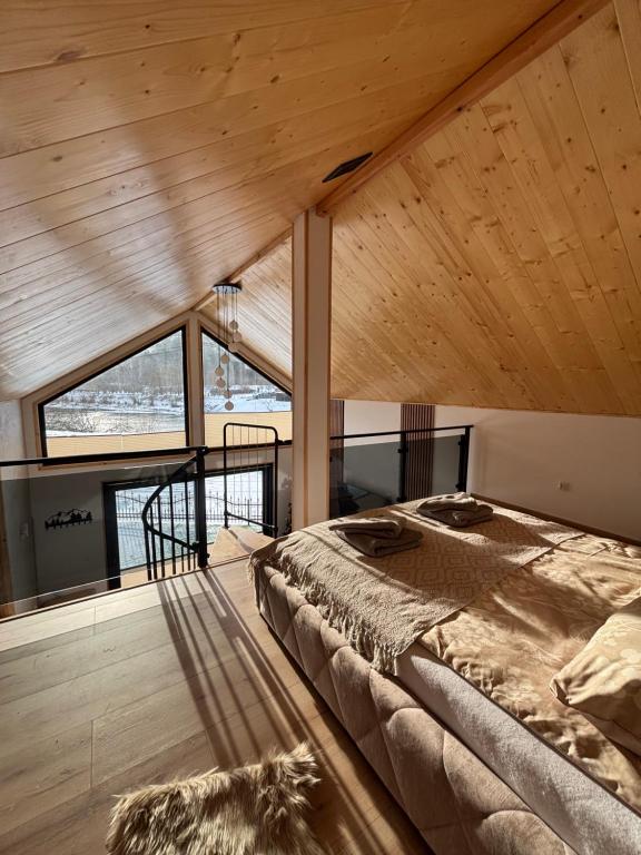 a bedroom with a large bed in a room with wooden ceilings at Stodoła Nad Dunajcem in Sromowce Wyżne