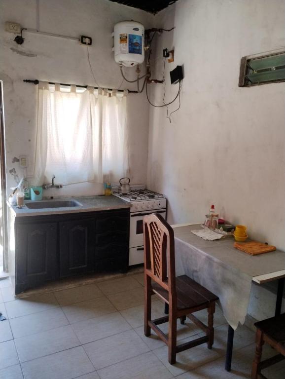 a kitchen with a table and a sink and a stove at Trotamundo in Los Polvorines