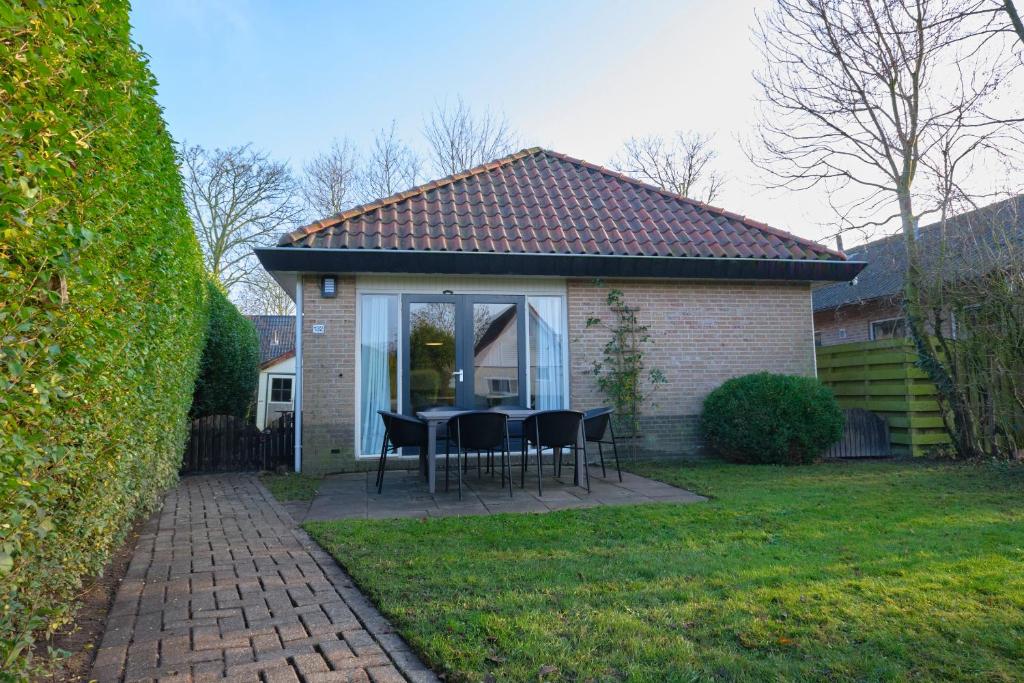 a house with a table and chairs on a patio at Vakantiewoning Hornzicht in Anjum