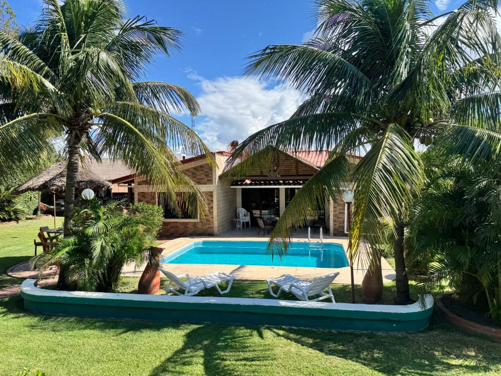 a villa with a swimming pool and palm trees at Casa por Temporadas in Santa Cruz de la Sierra