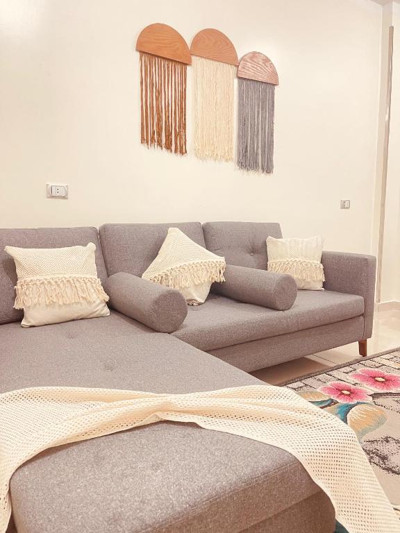 a living room with a gray couch with pillows at Blue rose in Abu Simbel
