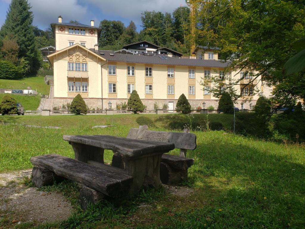 a wooden bench sitting in front of a large building at Königliche Villa - Watzmannblick - nahe Zentrum und Bahnhof in Berchtesgaden