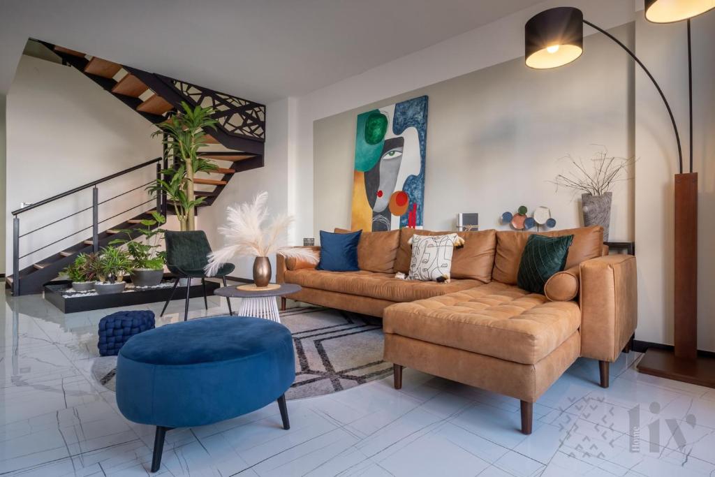 a living room with a couch and a blue chair at Exclusive Urban HomeResort in La Cañada