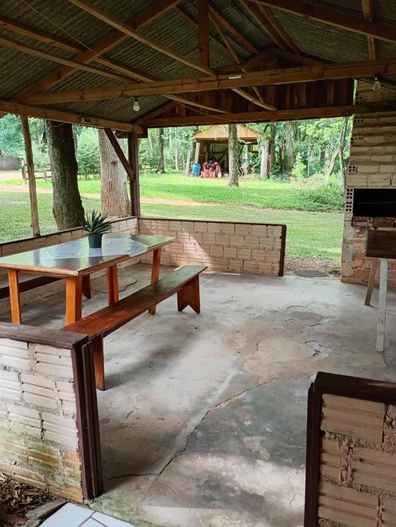 a picnic table and a bench under a pavilion at cabanas sossego in Água Boa
