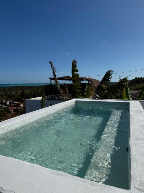 a swimming pool with the ocean in the background at Araxá Milagres in São Miguel dos Milagres