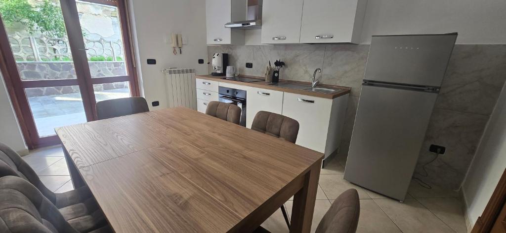 eine Küche mit einem Holztisch und einem Kühlschrank in der Unterkunft Jo Garden in Ercolano