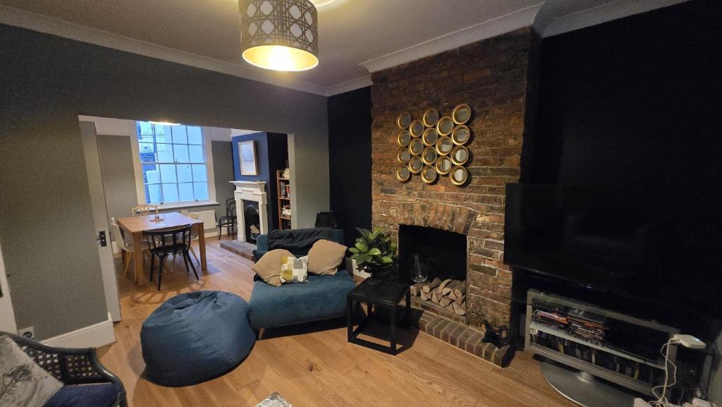 a living room with a fireplace and a tv at Seaside 4 bed terraced house in Hastings