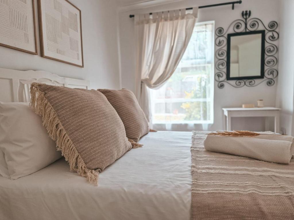 a white bedroom with a bed with a window at Dan en Wan in Agulhas