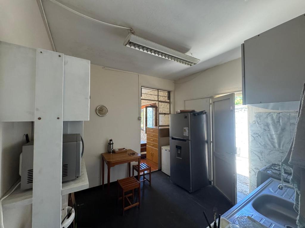 a kitchen with a refrigerator and a table at Apartamento Lomas de Solymar in Ciudad de la Costa