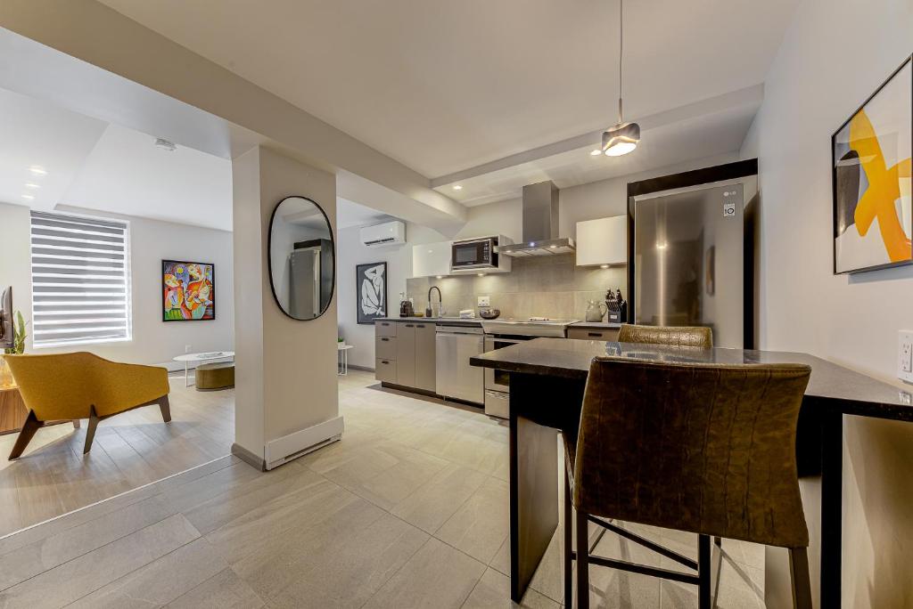 a kitchen with a counter and chairs in a room at 77 St-Vallier Apparts Hôtel in Quebec City