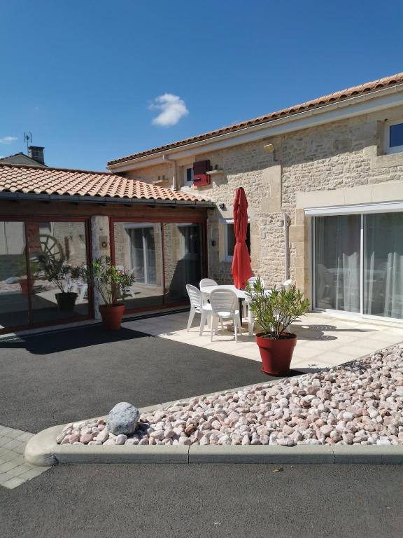 a house with a patio with a table and chairs at Gîte des forgerons in Sainte-Ouenne