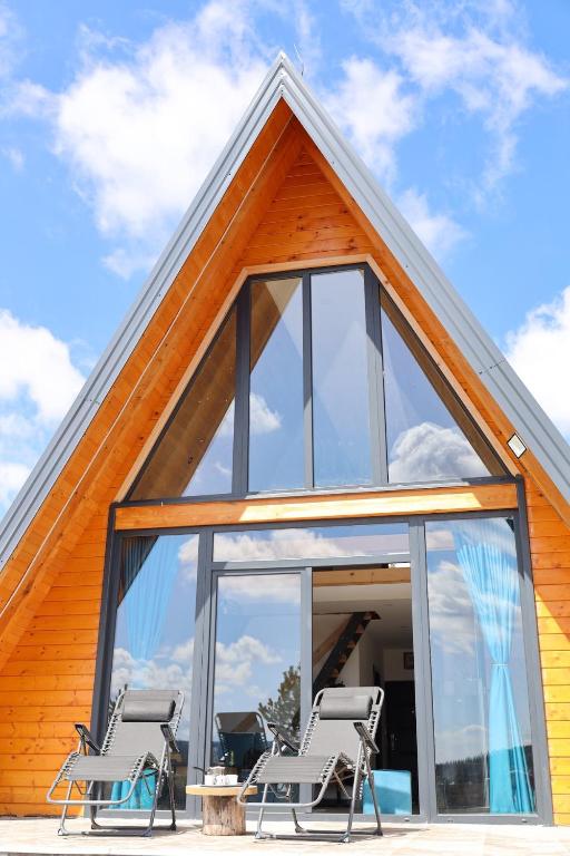 a house with a large window and two chairs at Panta Nature House in Dobrodoli