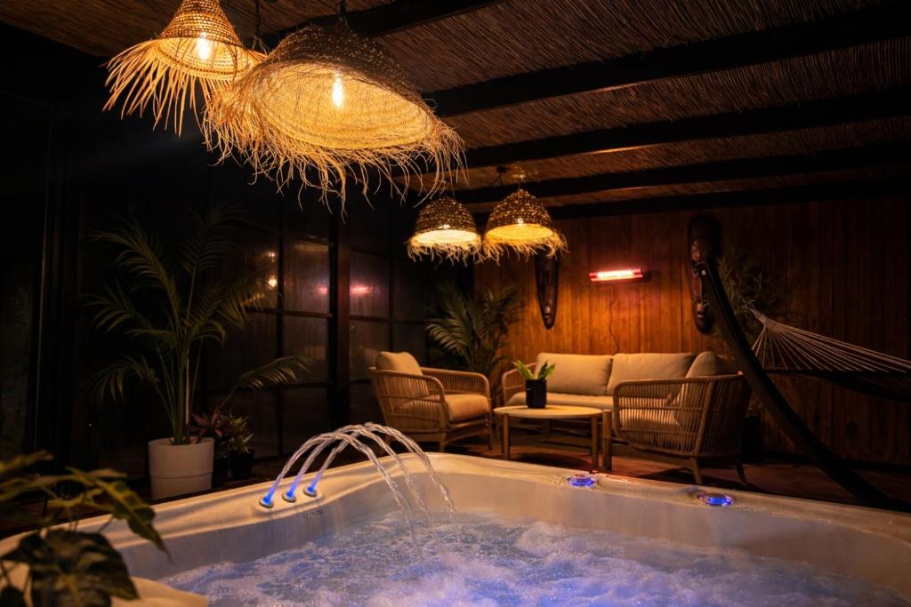 a jacuzzi tub in a room with chairs and lights at Slava Spa Relax House in Nakskov