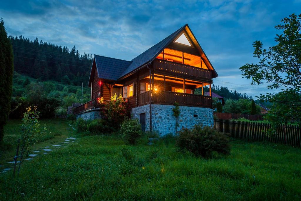 a house with lights on the side of it at Chalet M 1 in Lunca Bradului