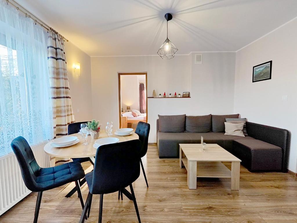 a living room with a table and a couch at Noclegi Sarenka in Murzasichle
