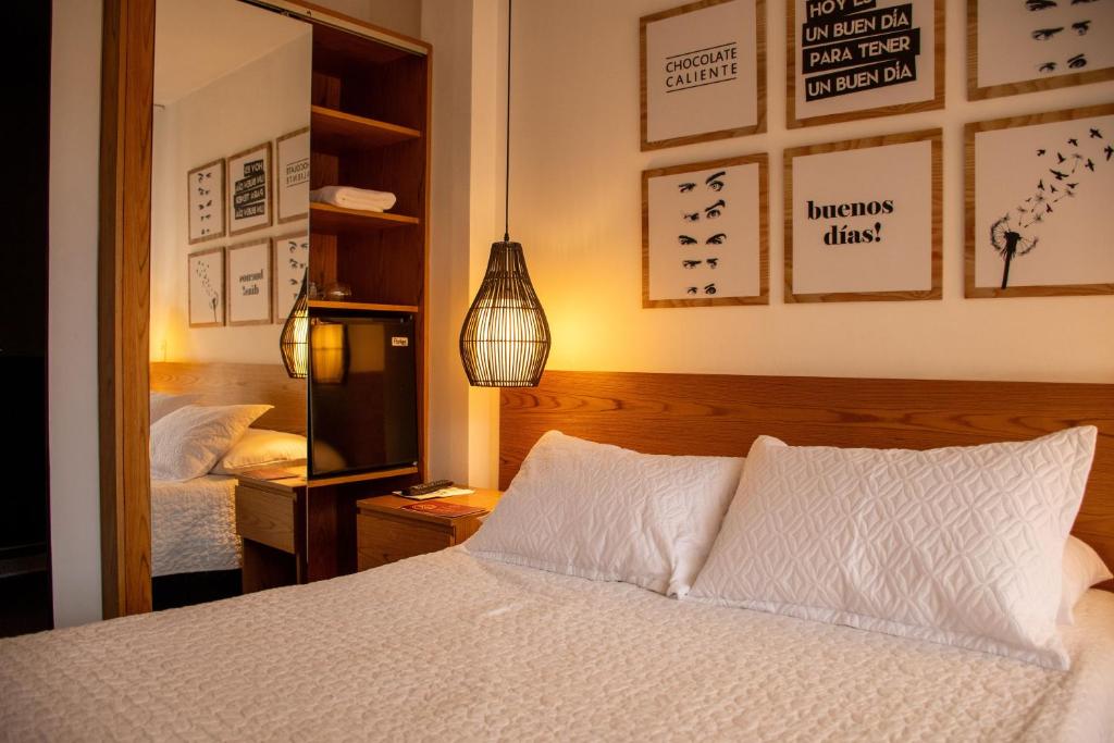 a bedroom with a white bed and a mirror at Hotel Santamaria INN in La Ceja