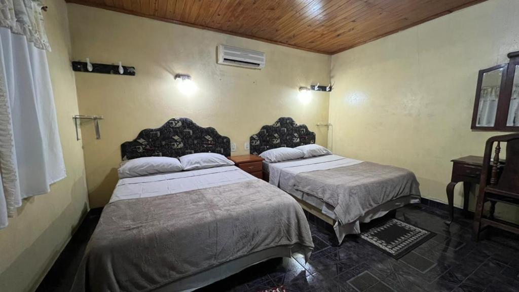 a bedroom with two beds and a wooden ceiling at Punto Clave in Posadas