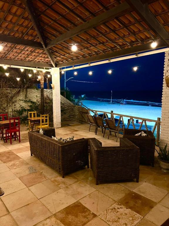 a patio with chairs and tables and a view of the ocean at Casa da Juma in Fortim
