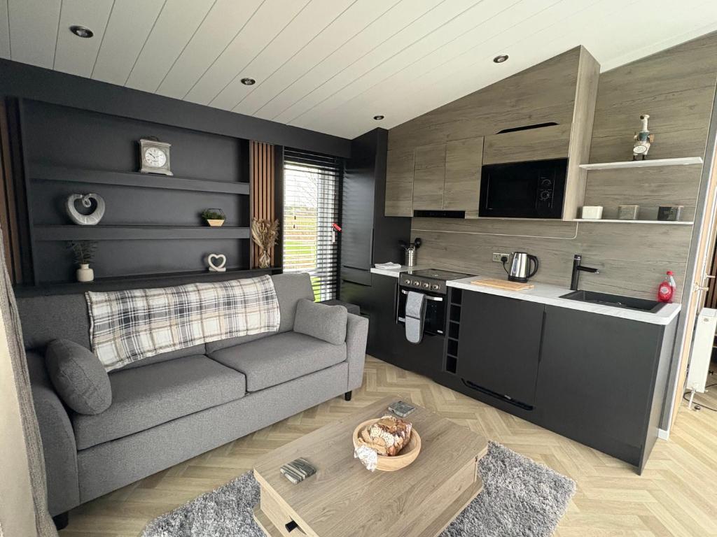 a living room with a couch and a kitchen at The paddocks in Wisbech