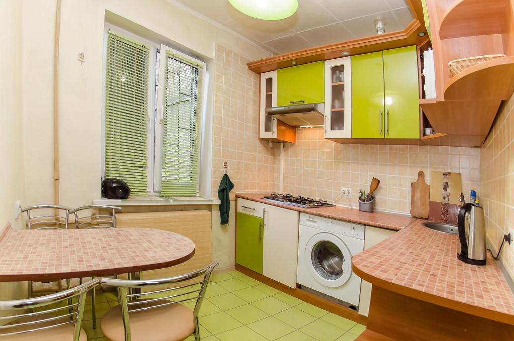 a kitchen with green cabinets and a washing machine at VIP apartment on 14 Vidradnyi Avenue in Kyiv