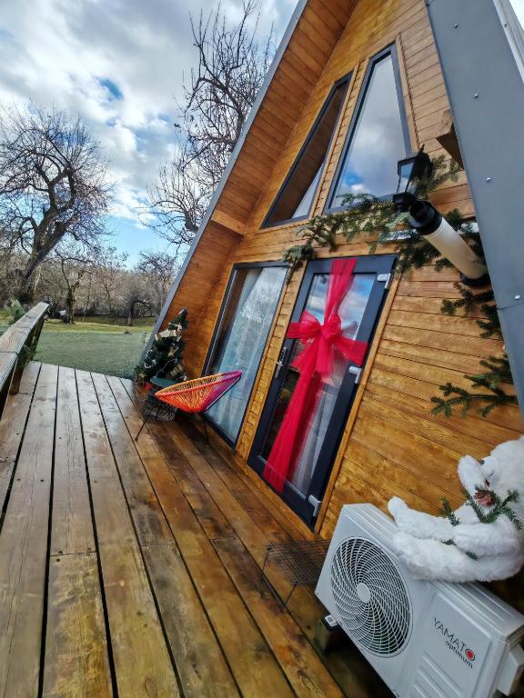 a house with a christmas bow on the door at Carpatina A-Frame Retreat - Rustic Cabins for Couples in Runcu