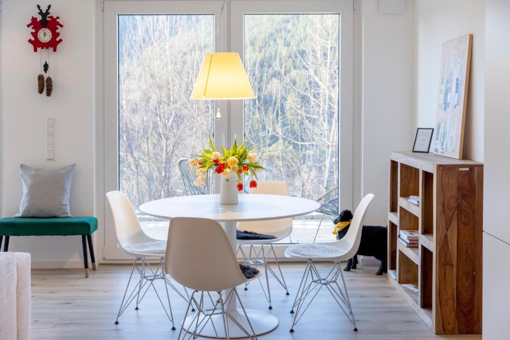 a dining room with a white table and chairs at Hermine, Black Forest Retreat, mit Sonnenterrasse in Baiersbronn