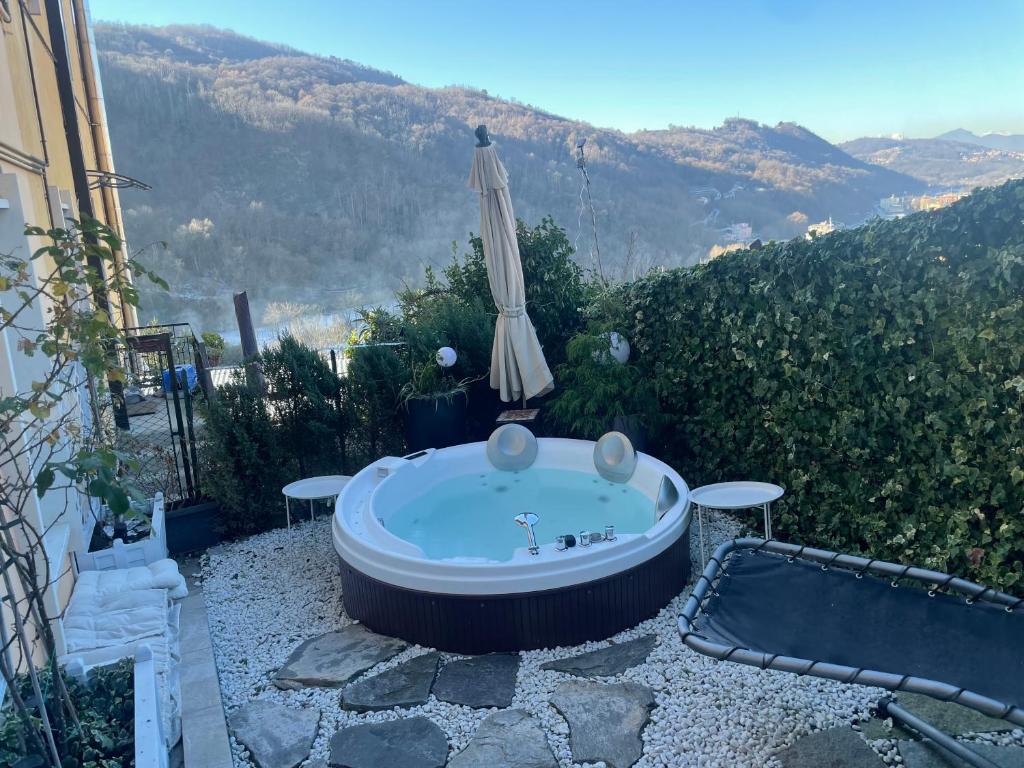 a jacuzzi tub with an umbrella on a patio at Casa Yuliya 11 in Como