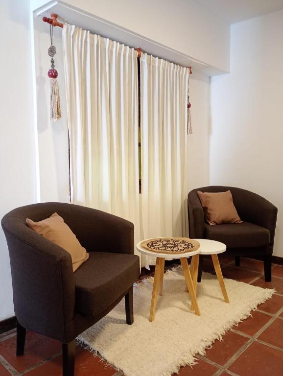 a living room with two chairs and a coffee table at Oro y Miel en pleno centro de Chascomús in Chascomús