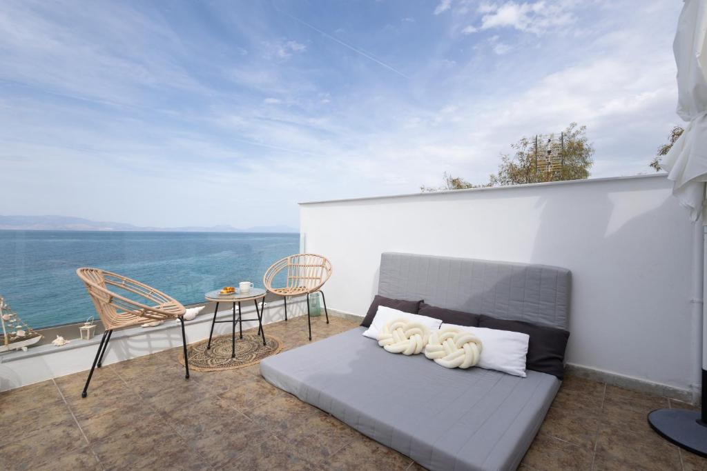 a bed on a balcony with a table and chairs at Myrto's Memories "My Sofitaki"- Seaview Studio in Melíssion