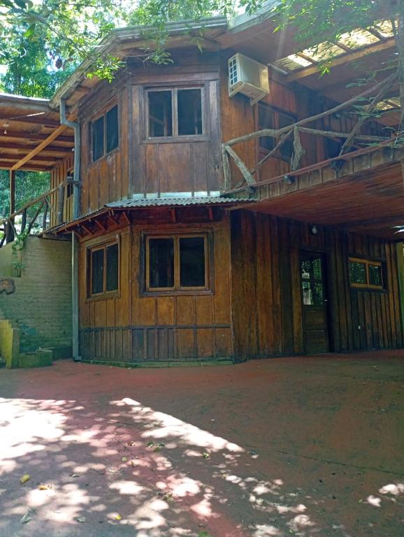 a wooden house with a balcony on top of it at Chacra Mariposas in Oberá