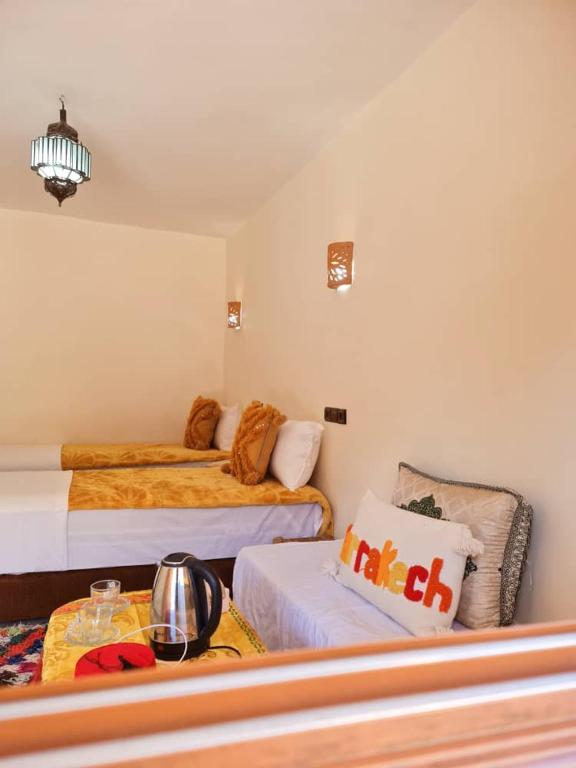 a hotel room with two beds and a table at Dar Benhoussa Imlil in Imlil