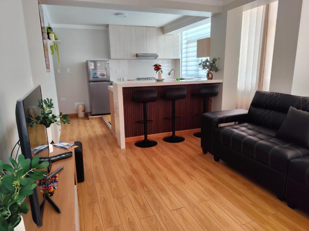 a living room with a couch and a kitchen at Apartamento Flores in Puno