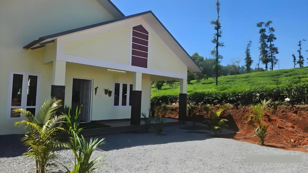 a small white house with a hill in the background at Beverly Hills Vagamon in Vagamon