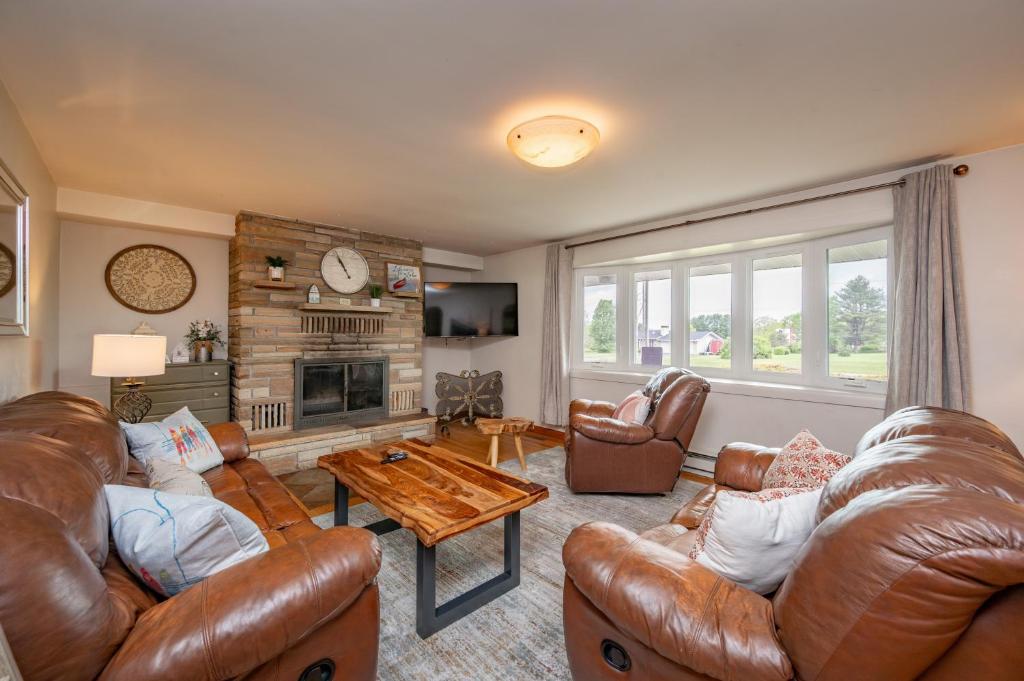 a living room with leather furniture and a fireplace at On Deep Creek Time by Railey Vacations in Friendsville