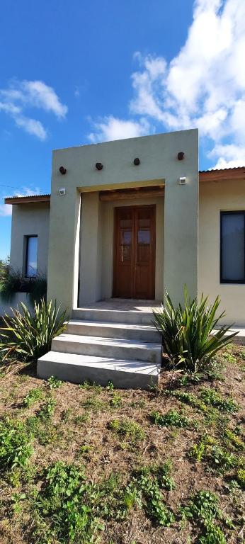 a house with a door and stairs in front of it at Casa de Campo Roca - Exclusivo para Parejas in Villa Cura Brochero