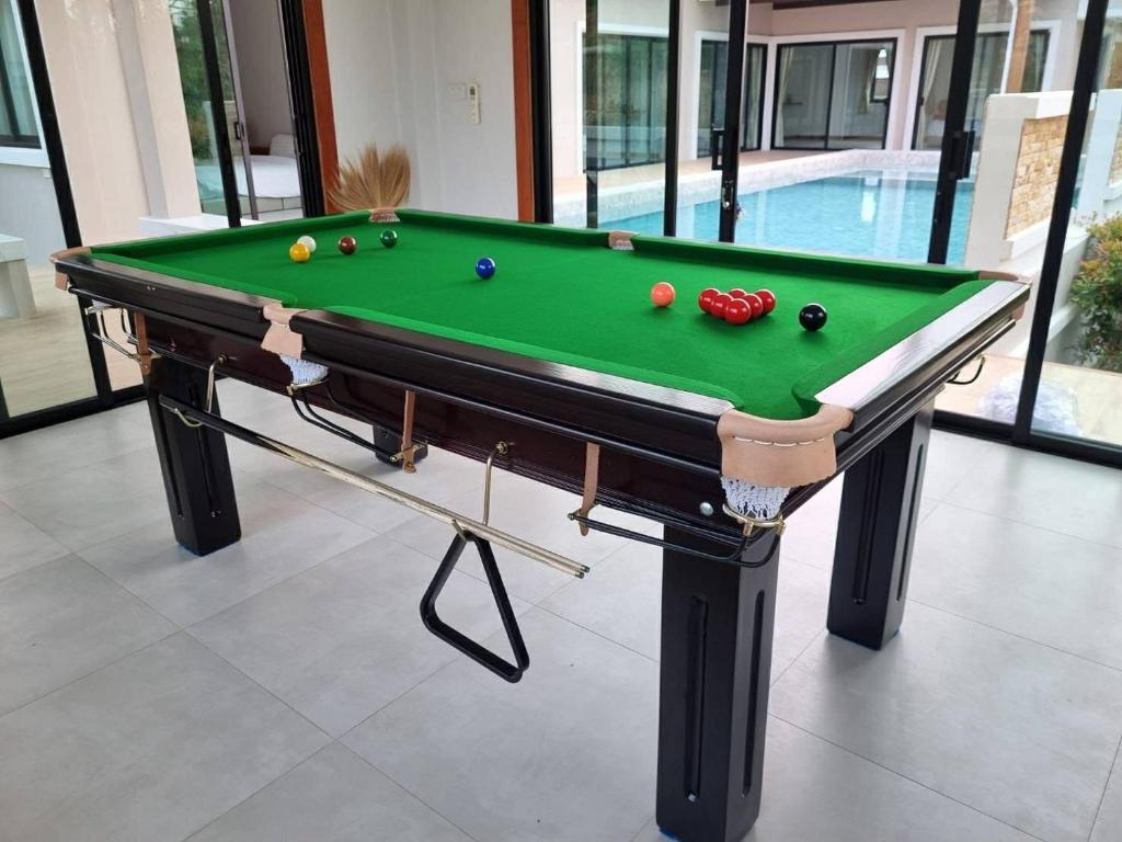 a pool table with balls on it in a house at บ้านครีมครูเมย์ พูลวิลล่า in Ban Nong Ban Kao