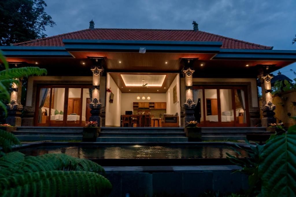 a house with a pond in front of it at Wanasari Villa in Tampaksiring