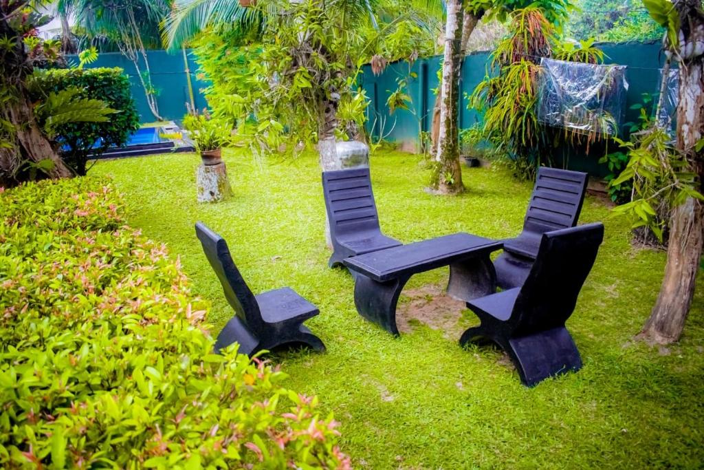 two chairs and a table in the grass at Casa Hikka Villa in Sinigama