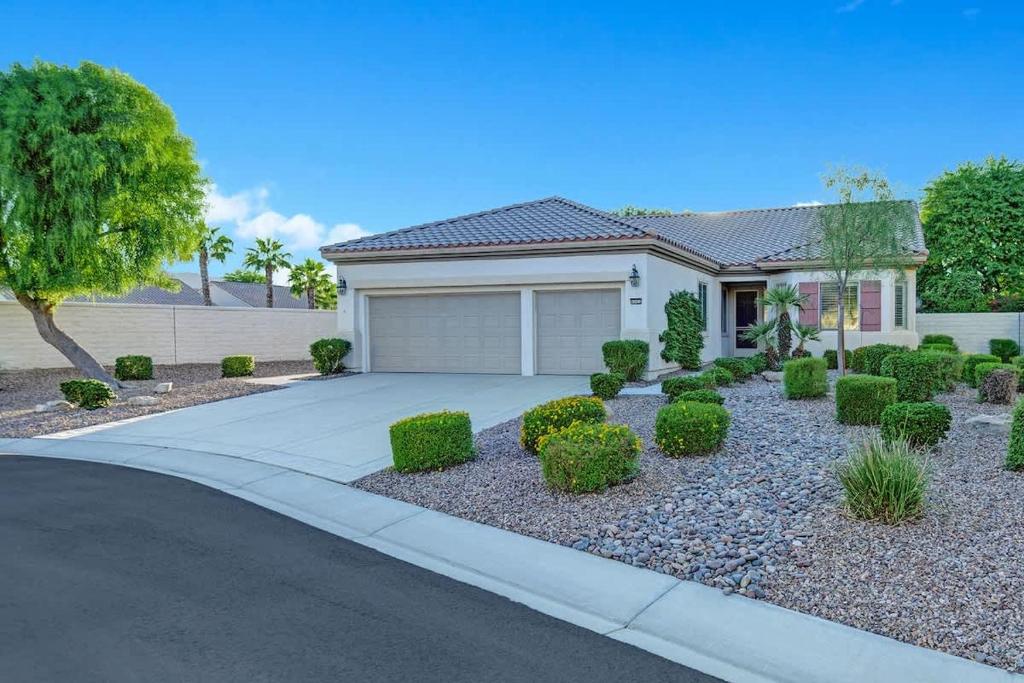 a house with a driveway and a garage at Sun City Fun - Alice Lodging in Indio