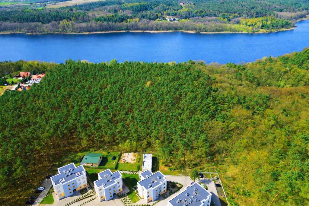 an aerial view of a house next to a lake at FoRest Longinówka - las, jezioro, parking, Netflix i Prime, TV55" in Brodnica