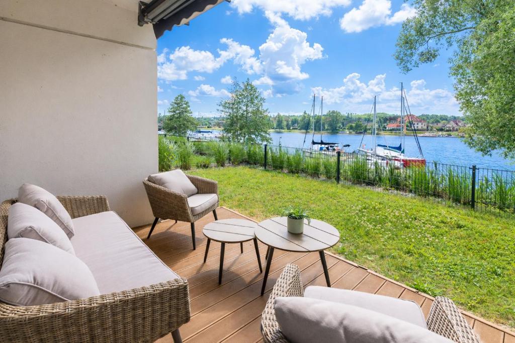 a patio with a view of the water at Port View - widok, 15m do jeziora, ogródek, parking podziemny, winda, Netflix i Prime in Iława